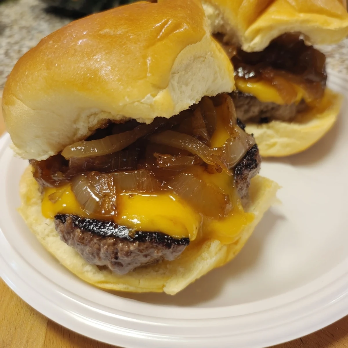 Golden-brown Beef Sliders with Caramelized Onions feature a delicious stack of flavors, ready to eat.
