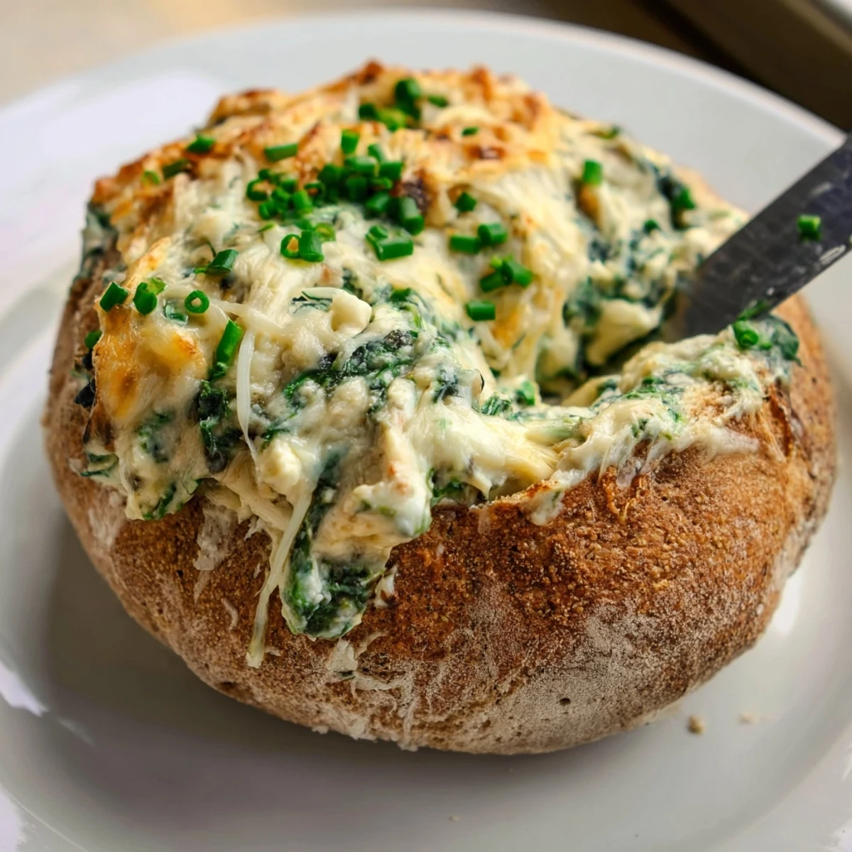 Creamy Spinach Dip served warm inside a hollowed, crusty sourdough bread bowl, ready for dipping.