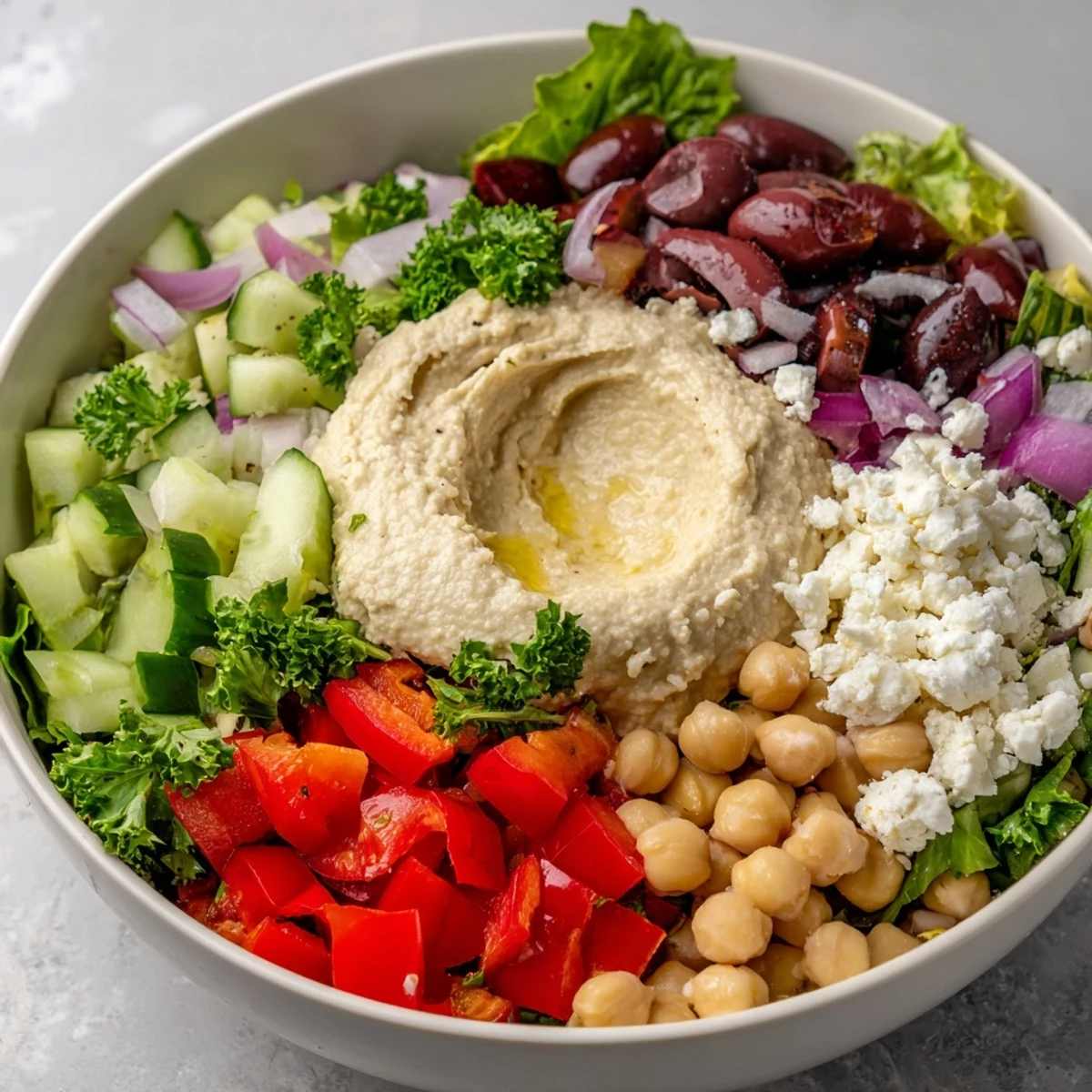 Fresh Mediterranean Salad with Hummus and colorful vegetables, served on a plate next to warm pita bread and a glass of white wine.