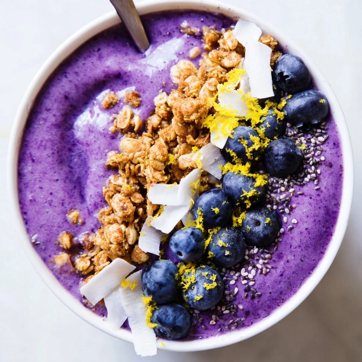 Thick, vibrant Lemon Blueberry Smoothie Bowl served with fresh blueberries, coconut flakes, and chia seeds for breakfast.