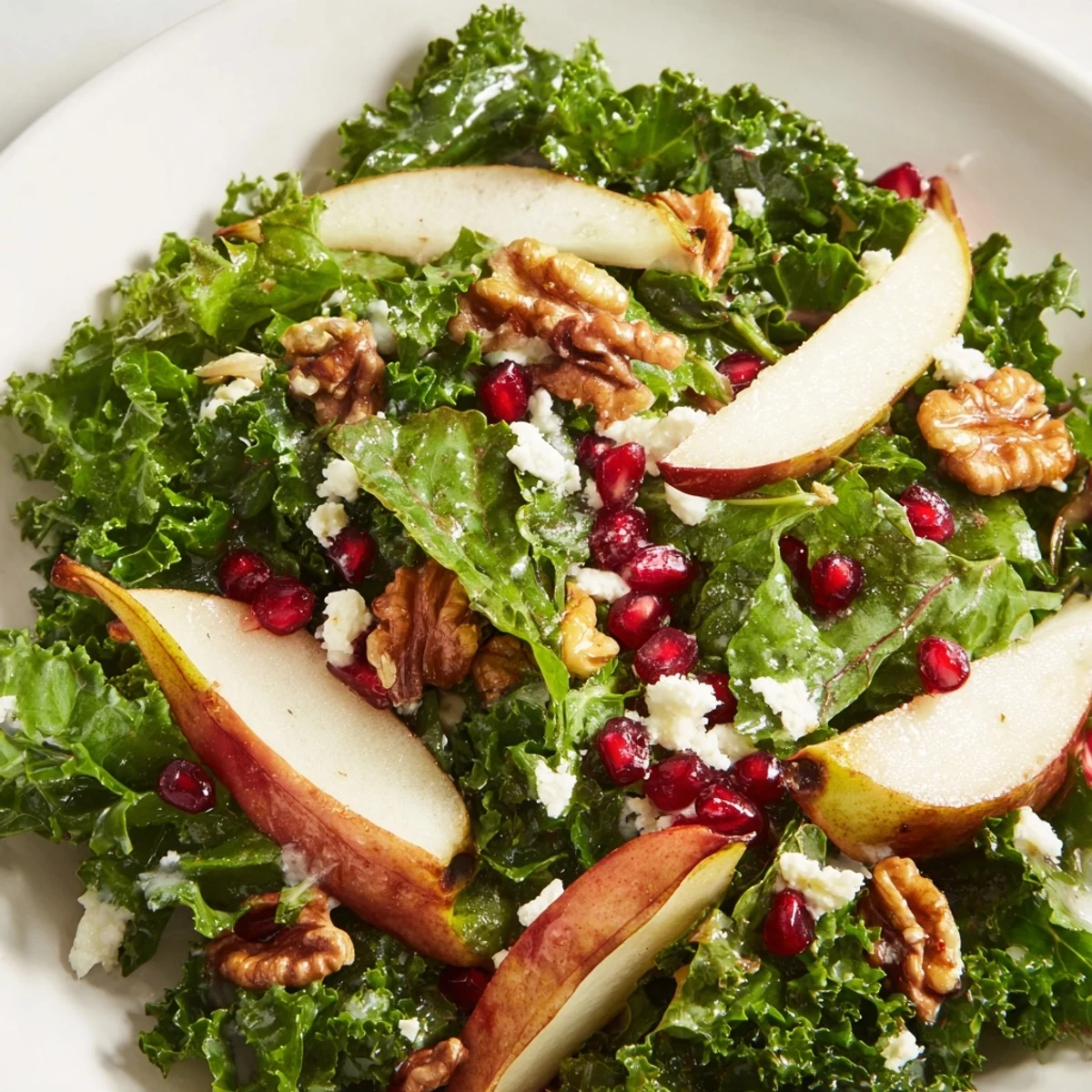 Winter Green Salad with Pear and Walnuts garnished with crumbled goat cheese, offering a vibrant, fresh lunch or dinner side dish.