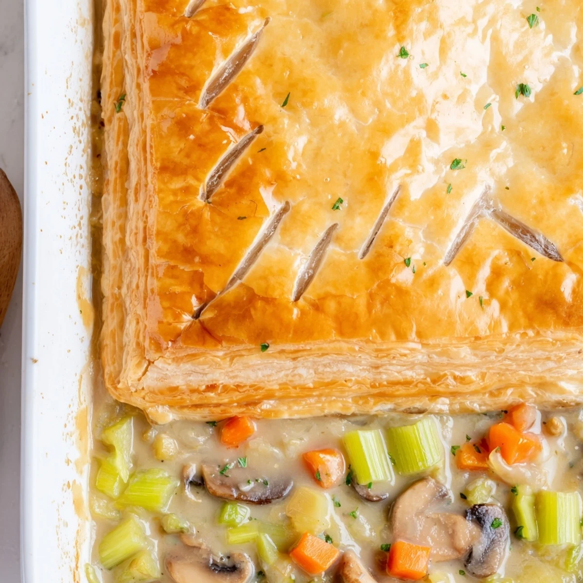 Comforting creamy mushroom and leek pot pie with golden crust, fresh thyme garnish, and a side salad.