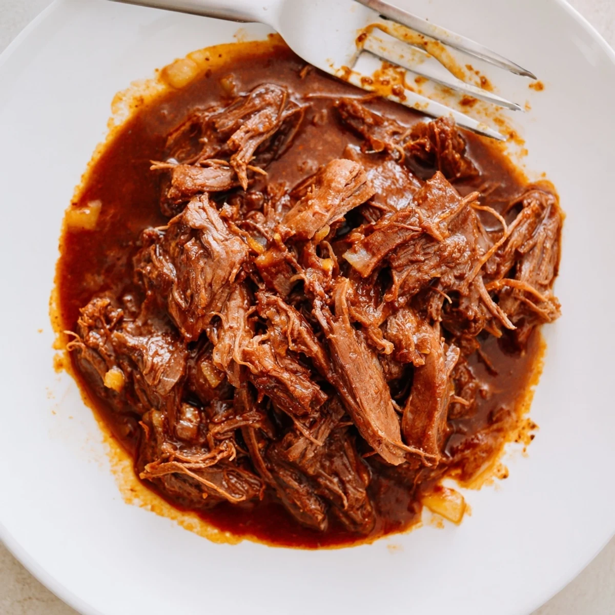 Golden sesame seeds and sliced green onions garnish a steaming bowl of Crock Pot Korean Beef, ready to be enjoyed with chopsticks on a wooden table.