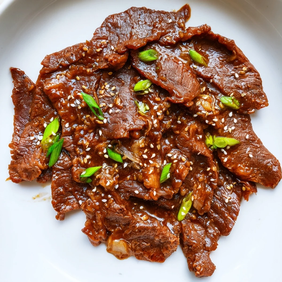 Ultimate Slow Cooker Mongolian Beef served in a ceramic bowl, fork-ready slices coated in savory-sweet glaze.