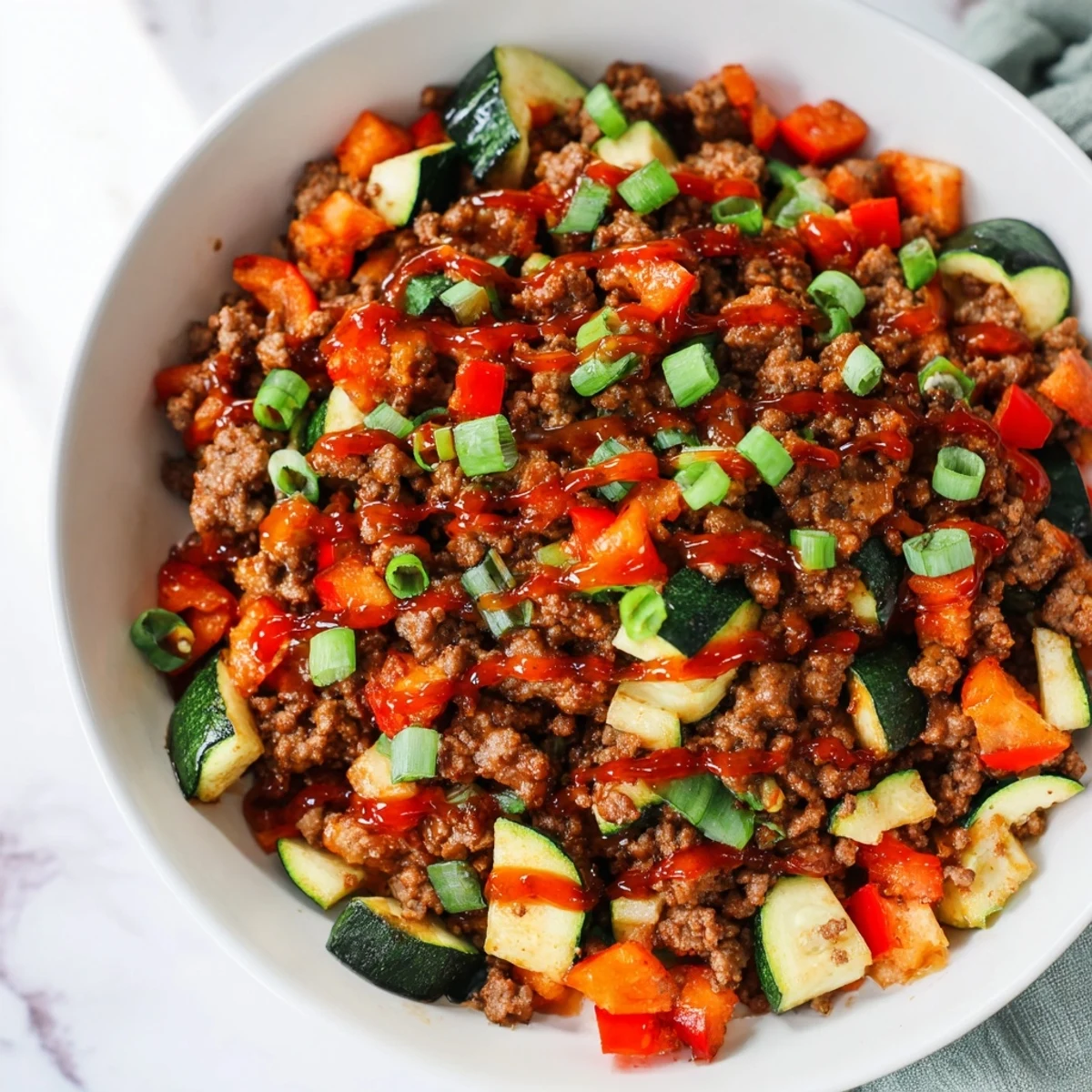 Steam rises from the hot honey drizzle over the Viral Hot Honey Ground Beef Bowl with roasted vegetables.