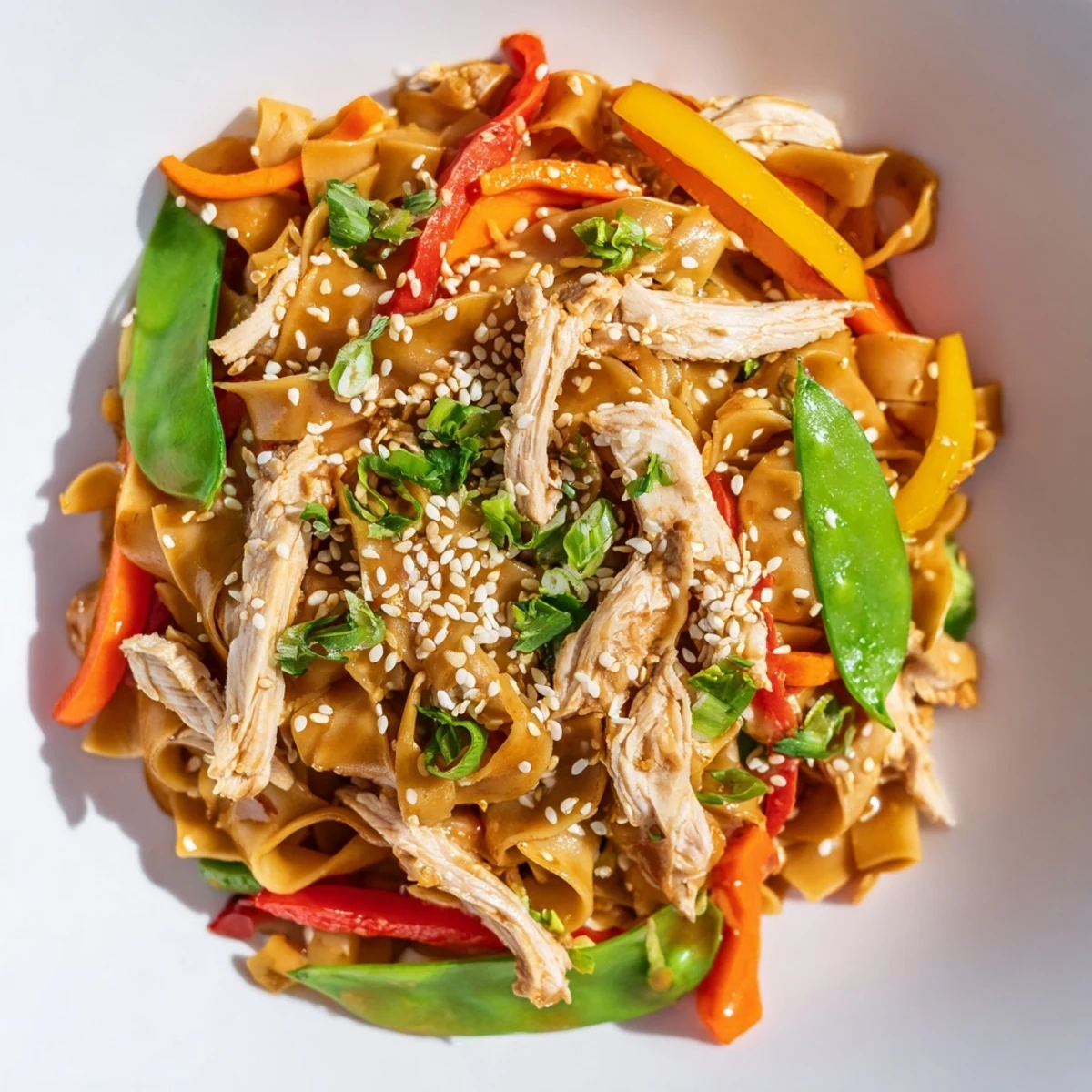 Plated Sweet Chilli Turkey Noodle Stir Fry garnished with fresh coriander, sesame seeds, and lime wedges, perfect for a weeknight dinner.