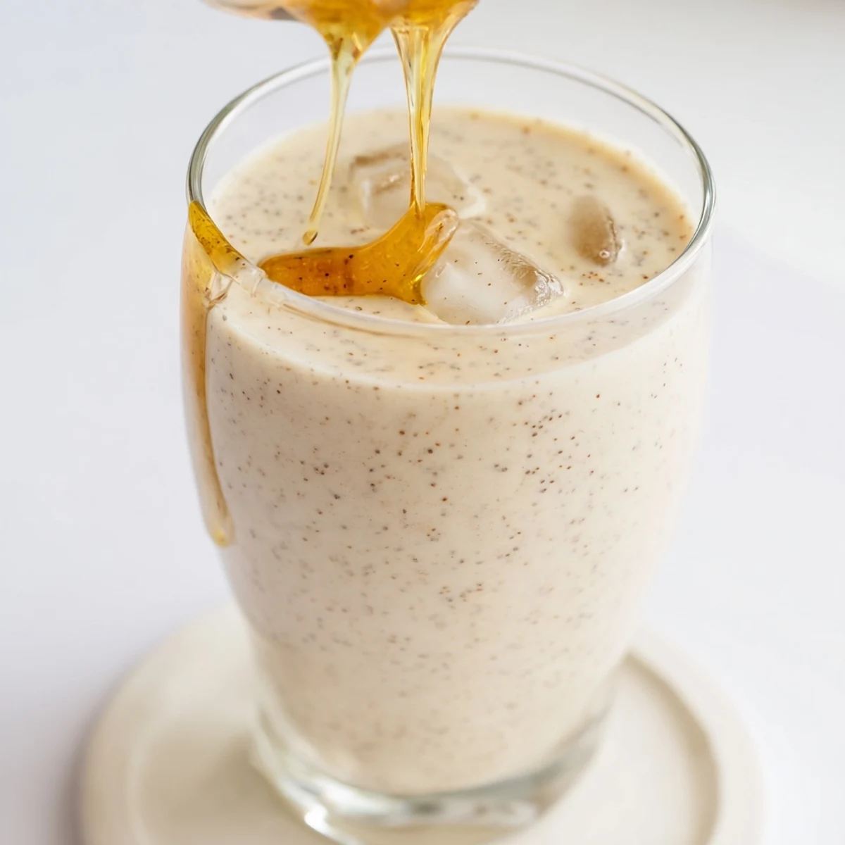 Thick and frothy Greek yogurt banana smoothie blended with ice for a refreshing breakfast