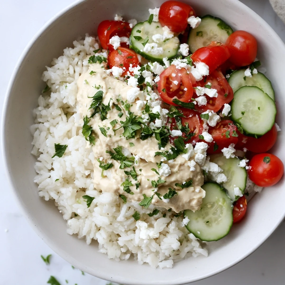 Mediterranean rice bowl arranged with chickpeas olives and zesty tahini dressing