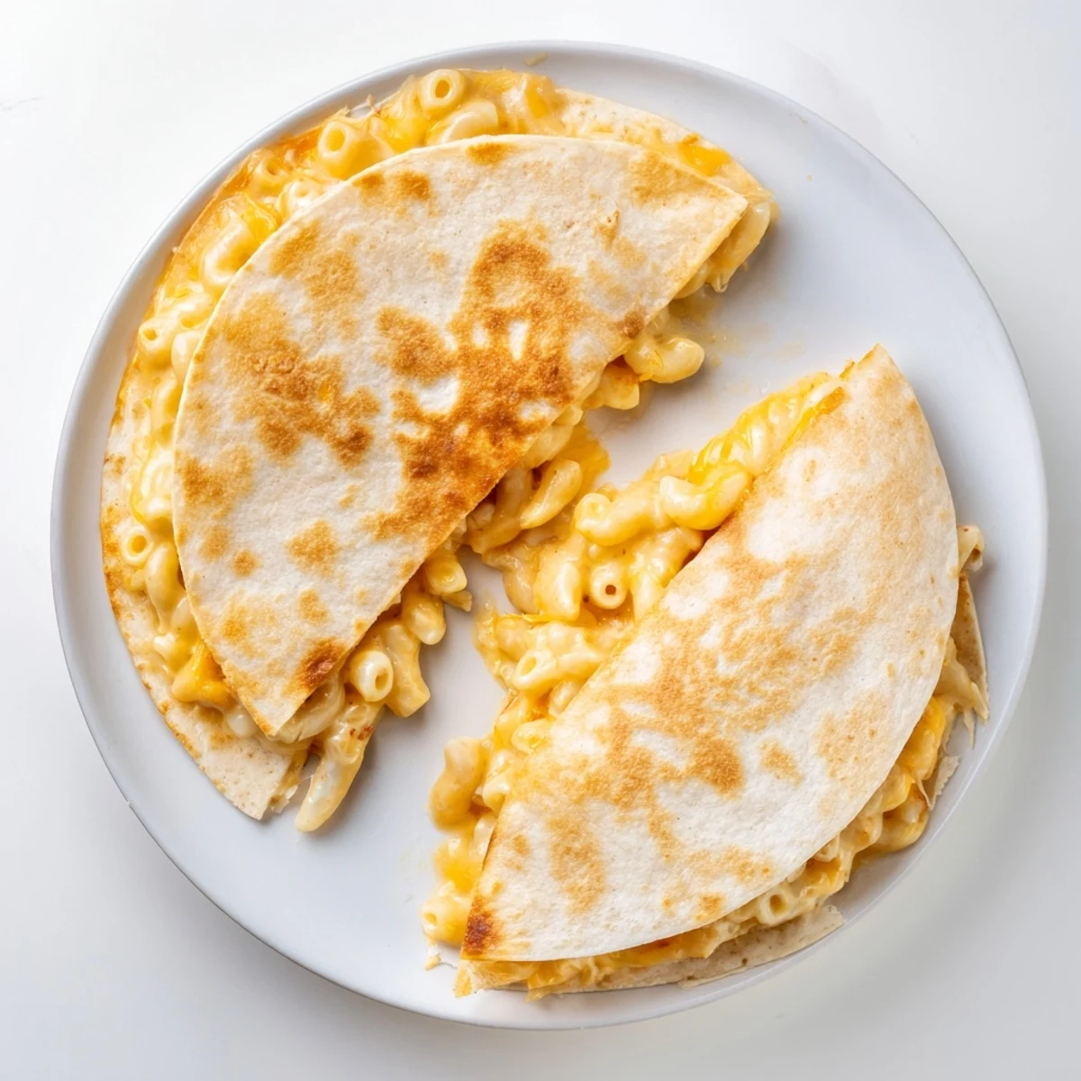 Creamy macaroni and cheese melted inside a toasted flour tortilla with oozing cheddar