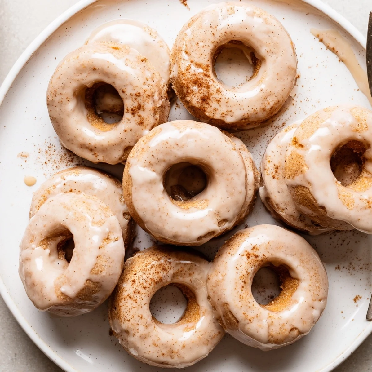 Golden maple pumpkin mochi donuts topped with sweet glaze and dusted with ground cinnamon