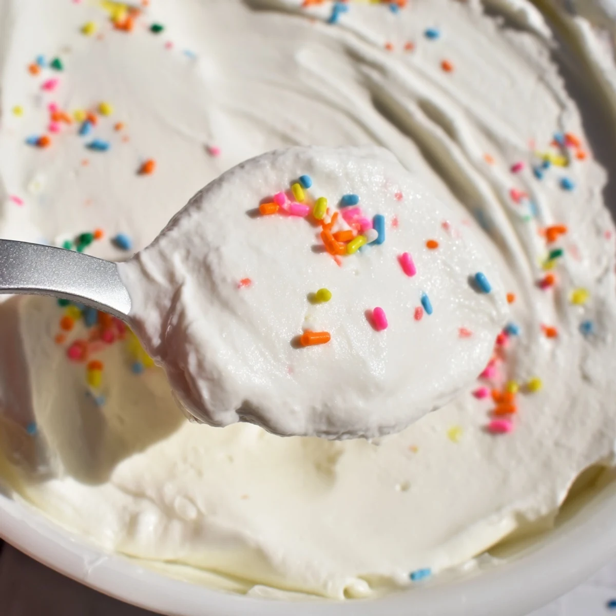 Creamy high protein Dunkaroo dip topped with colorful rainbow sprinkles in a serving bowl