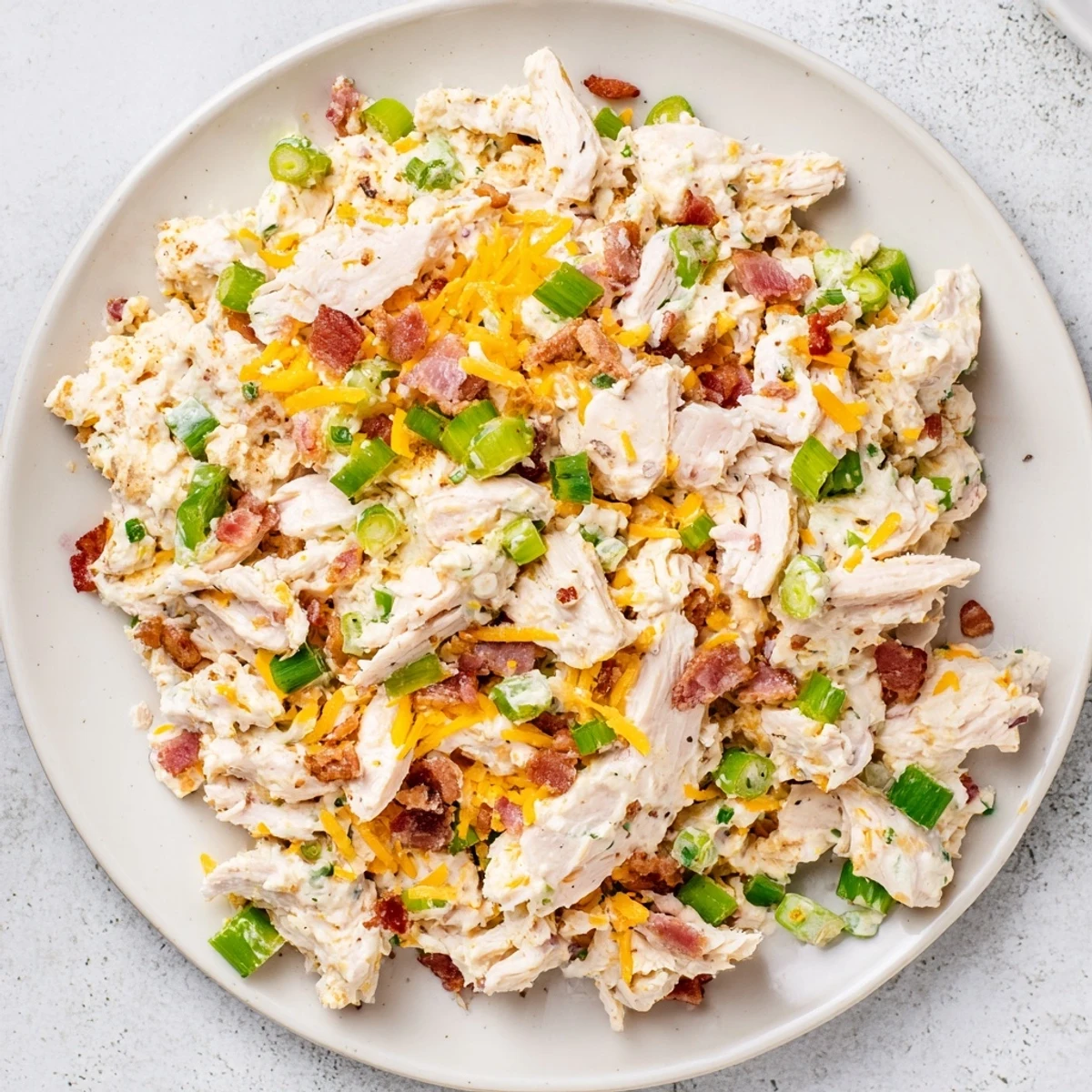 Spoonful of zesty low carb jalapeno popper cottage cheese chicken salad served on crisp green lettuce leaves for a gluten-free lunch