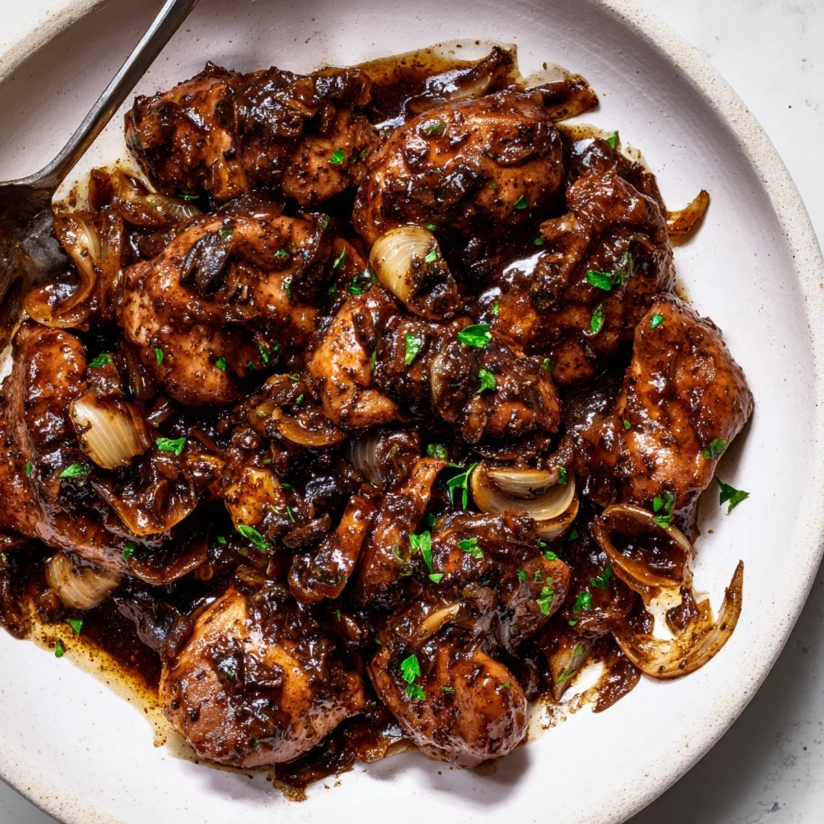 Golden brown chicken thighs simmered in rich balsamic glaze with caramelized onions