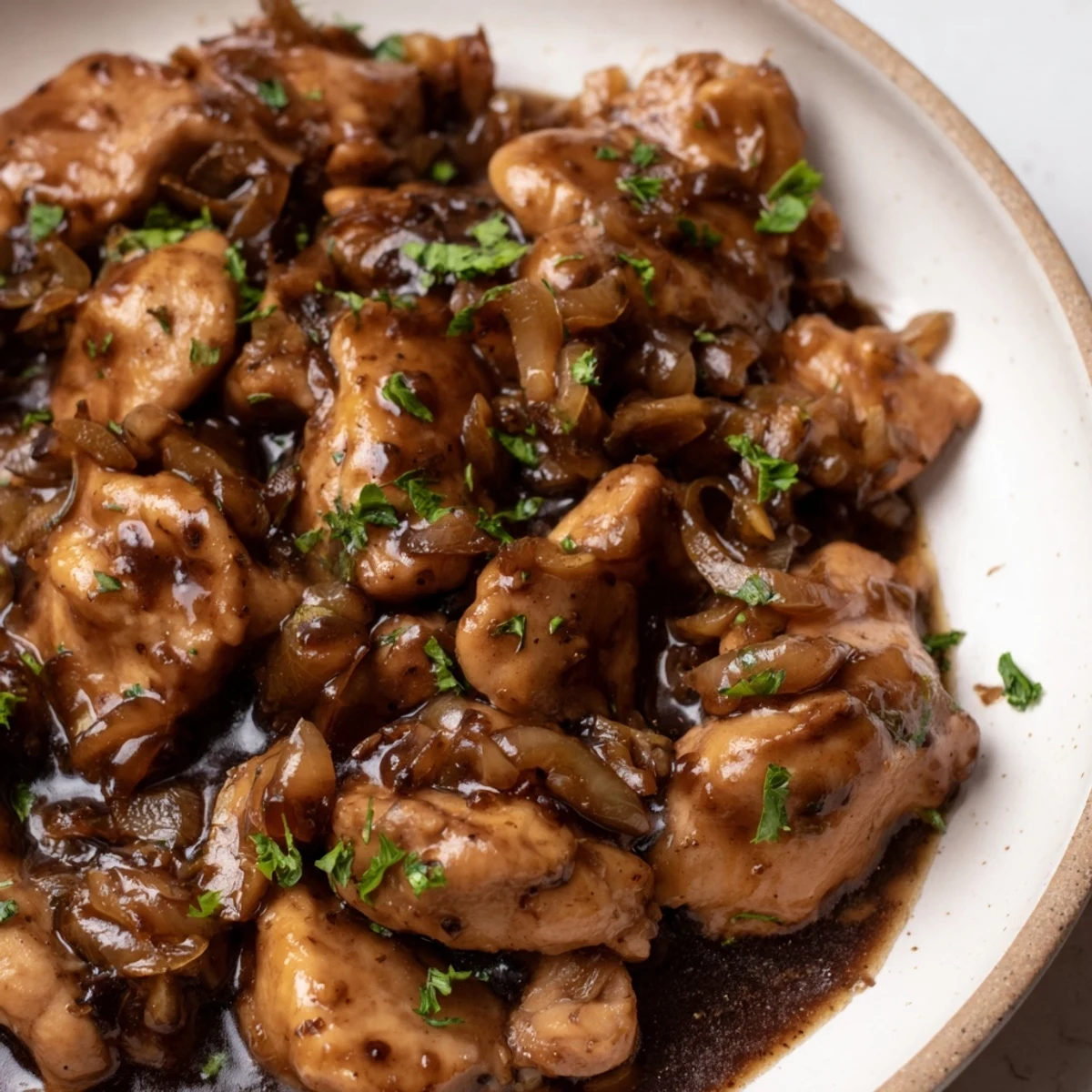 Tender slow cooker balsamic chicken garnished with fresh parsley over steaming white rice