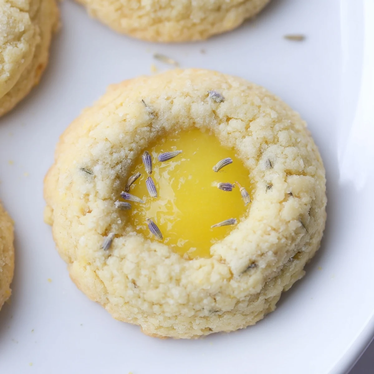 Buttery shortbread cookies filled with bright lemon curd and dotted with edible lavender buds