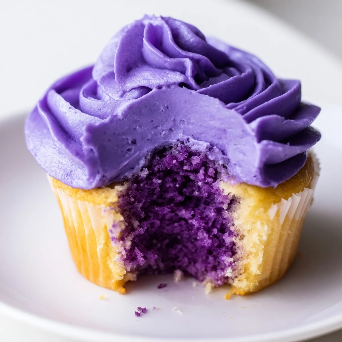 Stack of grape soda cupcakes showing purple crumb and smooth grape buttercream topping