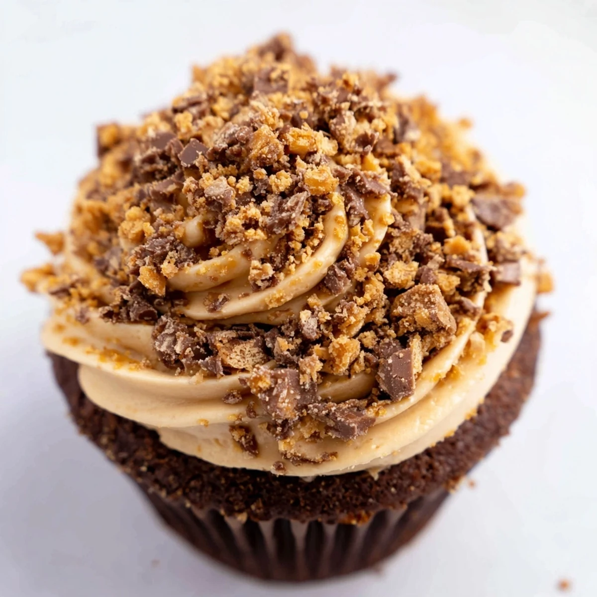 Decadent Butterfinger cupcakes with chocolate cake, peanut butter filling, and crunchy candy topping.