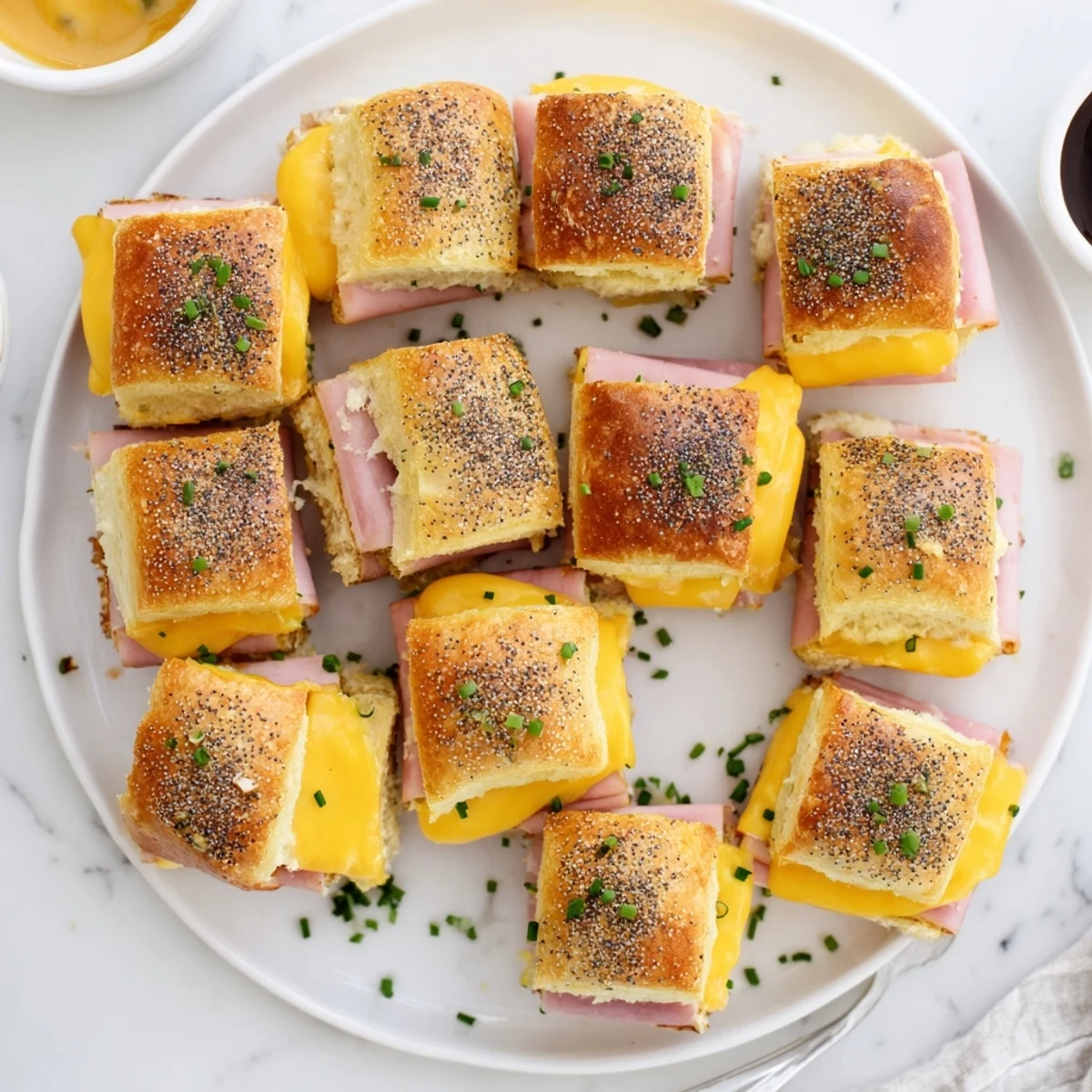 Sweet and savory mini grilled cheese Hawaiian rolls with honey mustard brushed crusts and oozing cheese