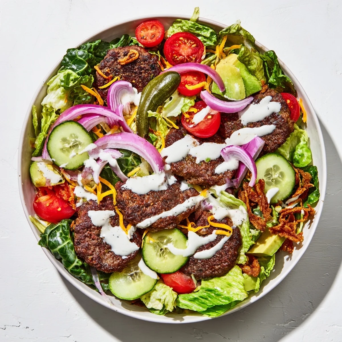 Golden crispy smash burger patties served over fresh greens with tangy pickles and creamy smash sauce