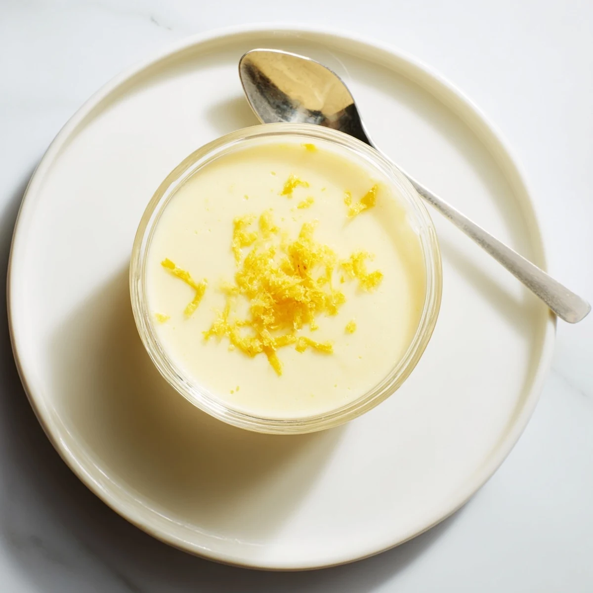 Creamy lemon posset served in clear glass with fresh berry garnish