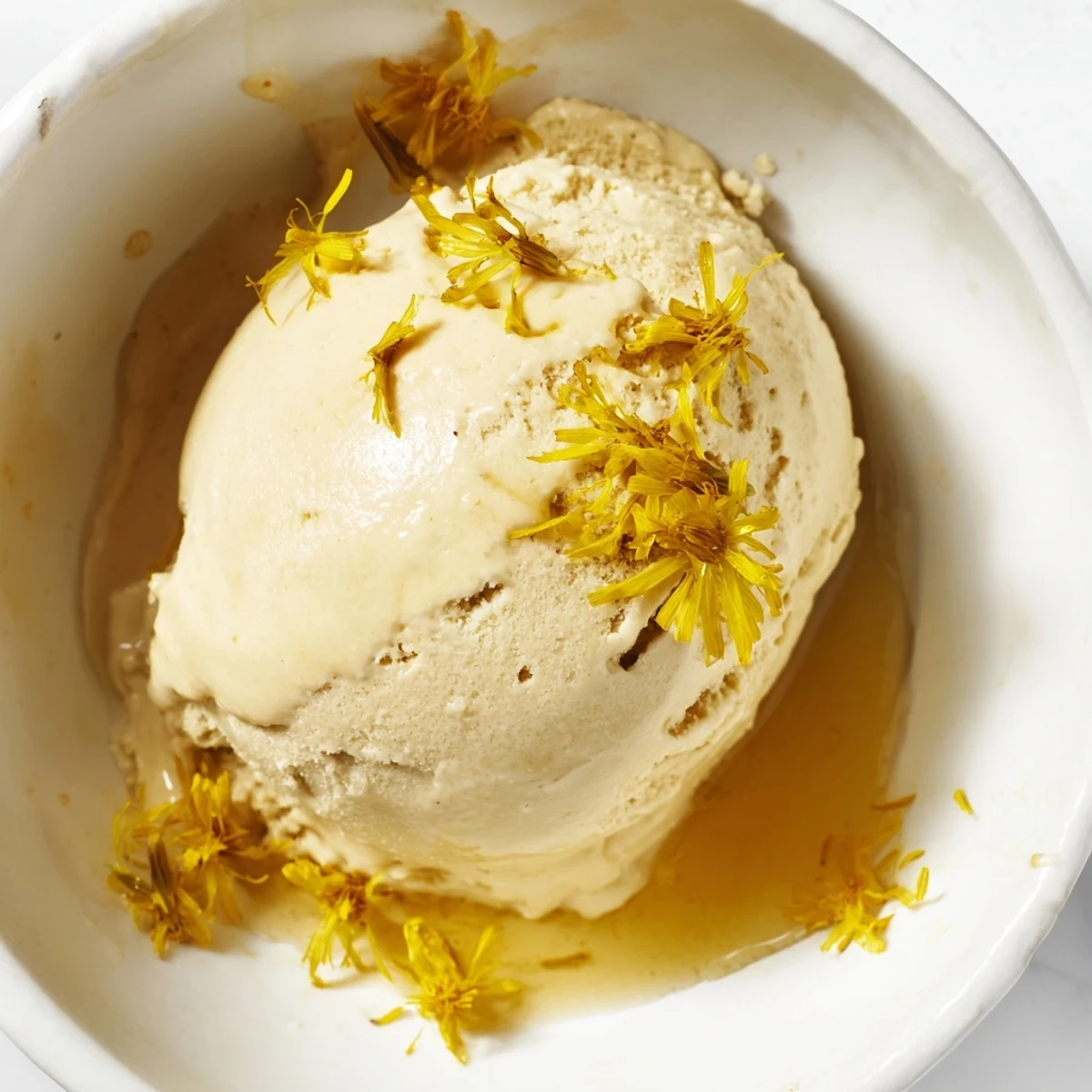 Velvety floral ice cream bowl garnished with fresh dandelion petals on wooden table