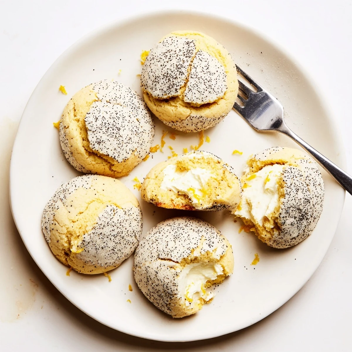 Close-up of lemon poppy seed cheesecake cookie showing visible poppy seeds and cheesecake filling