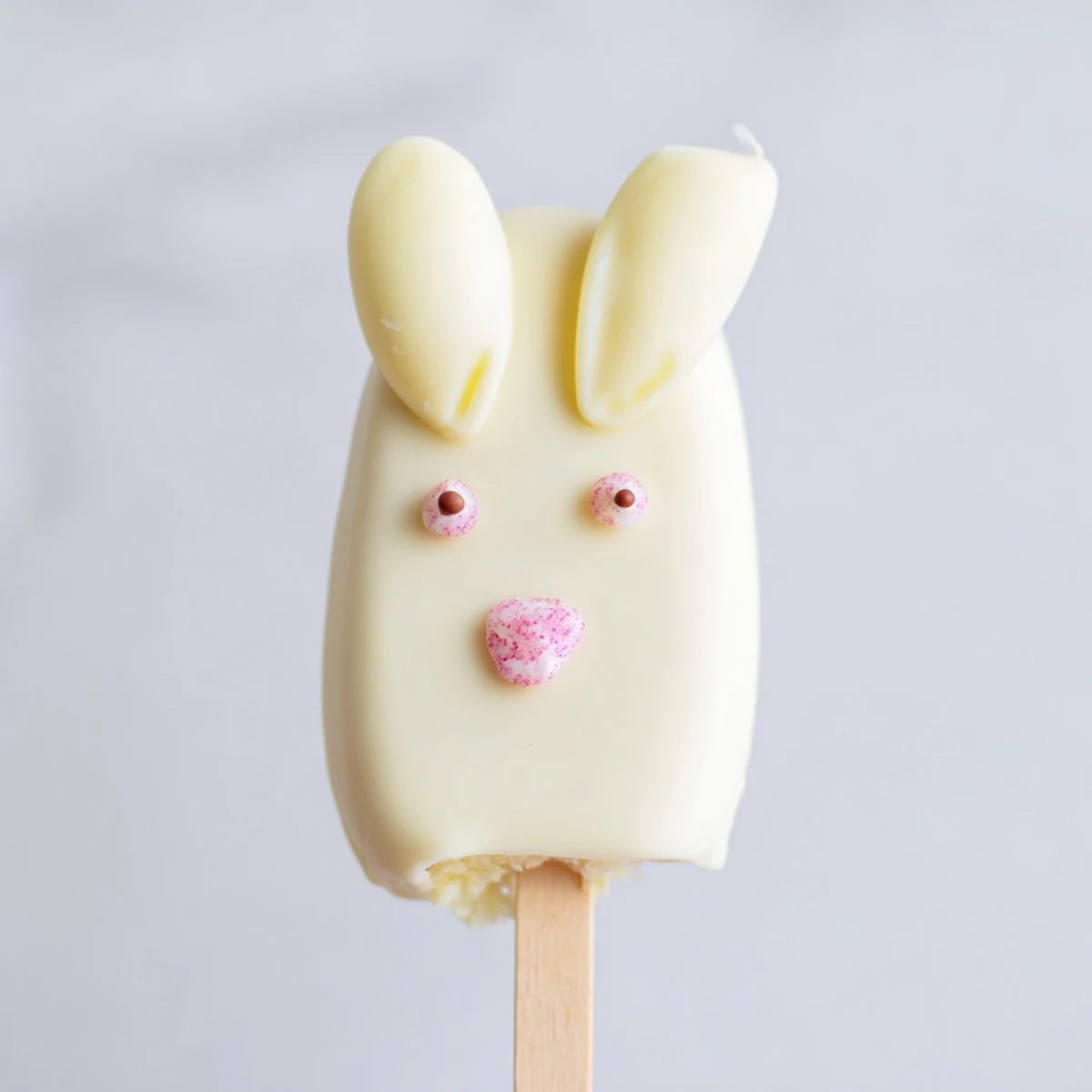 Creamy white chocolate bunny cakesicles decorated with sprinkles for festive Easter treats