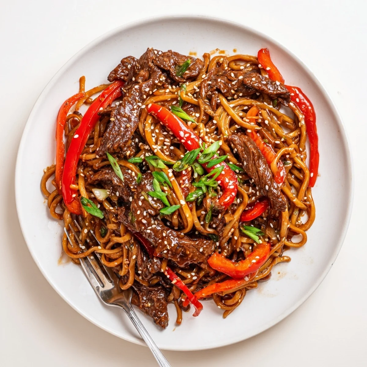 Wok-tossed Sticky Beef Noodles coated in sweet savory sauce, glossy and chewy