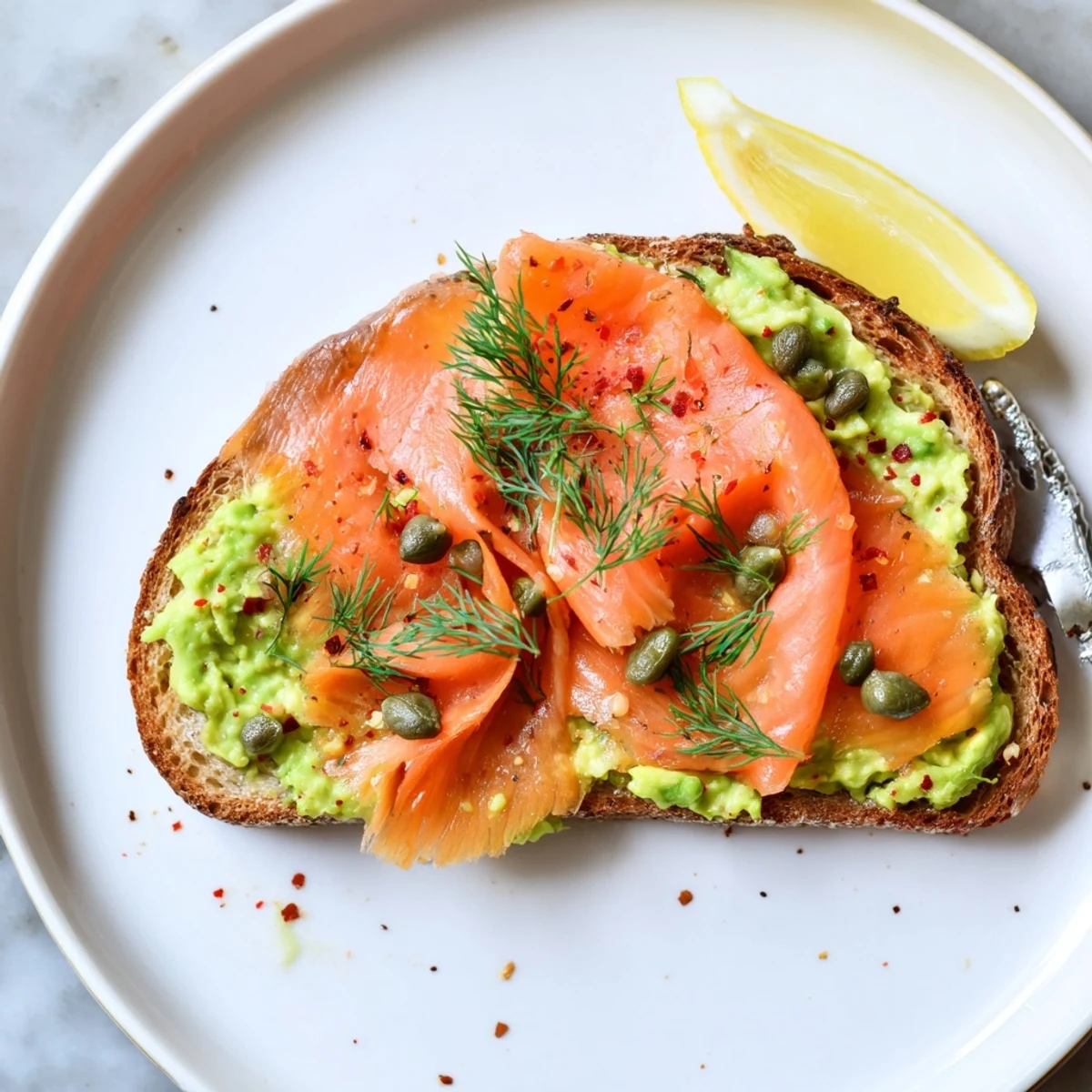 Smoky Salmon Avocado Toast topped with flaky slices, capers, and fresh dill