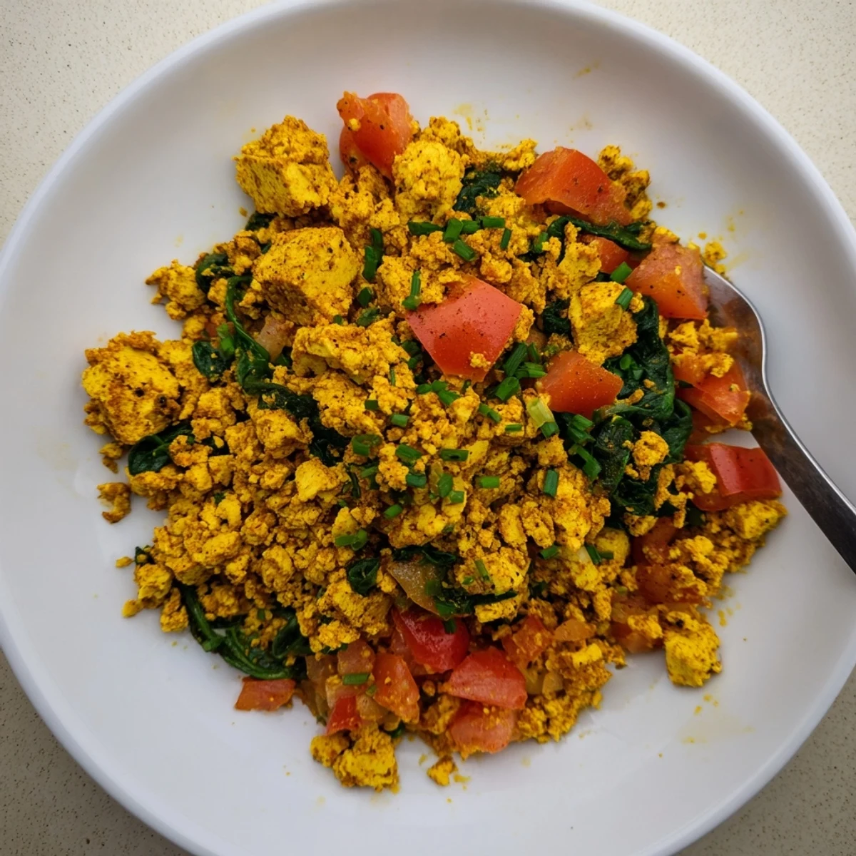 Creamy tofu scramble served with avocado toast, chives, and pepper