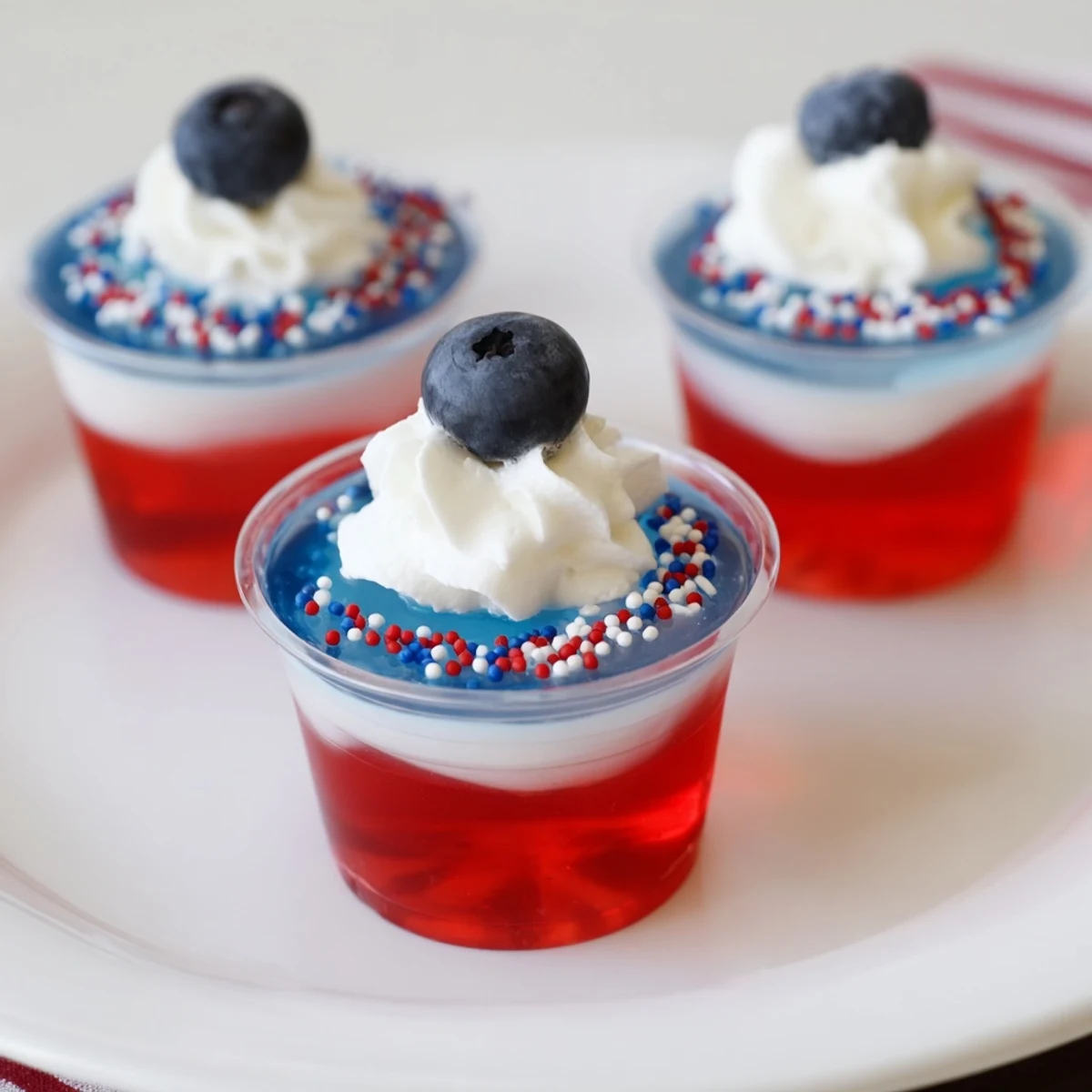 Red White And Blue Jello Cups chilled in clear cups, glossy layers