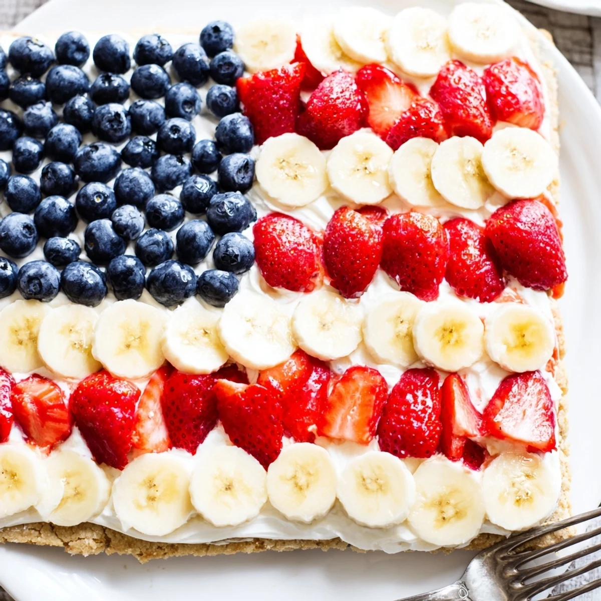 American Flag Fruit Pizza on a golden cookie crust, creamy frosting, juicy berries