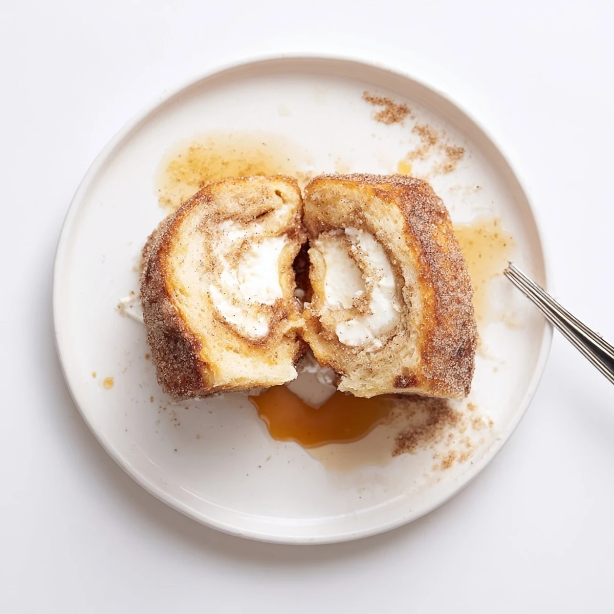 Cinnamon Roll French Toast Roll Ups sizzling golden, dusted in cinnamon sugar  