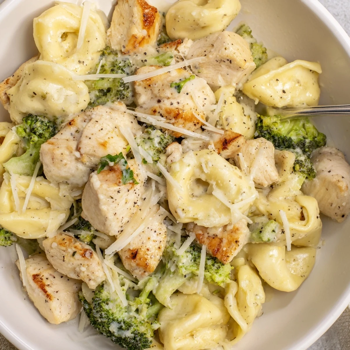 Creamy Garlic Parmesan Tortellini Chicken Broccoli Recipe steaming, golden chicken, crisp green florets.