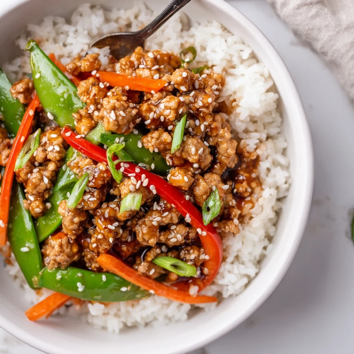 Steaming Teriyaki Turkey Rice Bowls garnished with sesame seeds and sliced scallions
