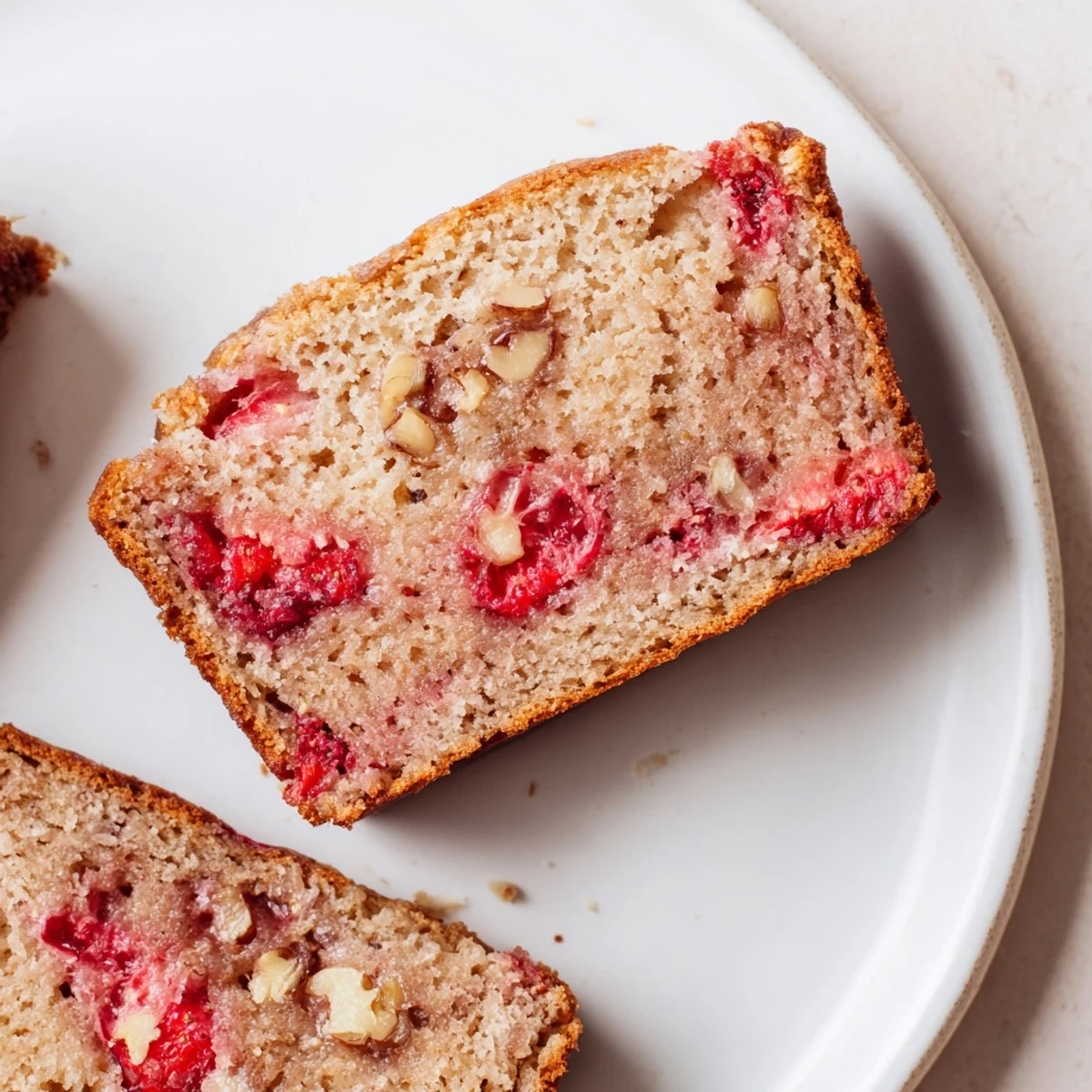 Slice of Strawberry Banana Bread Recipe served warm with honey drizzle.