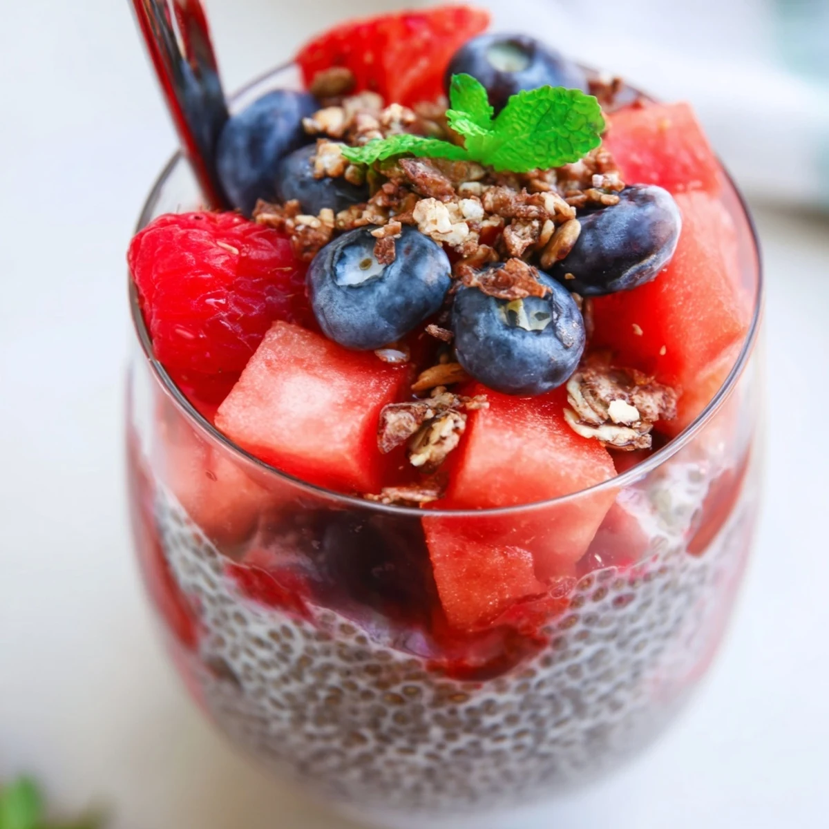 Chilled Watermelon Chia Parfait in glass jar, topped with crunchy granola