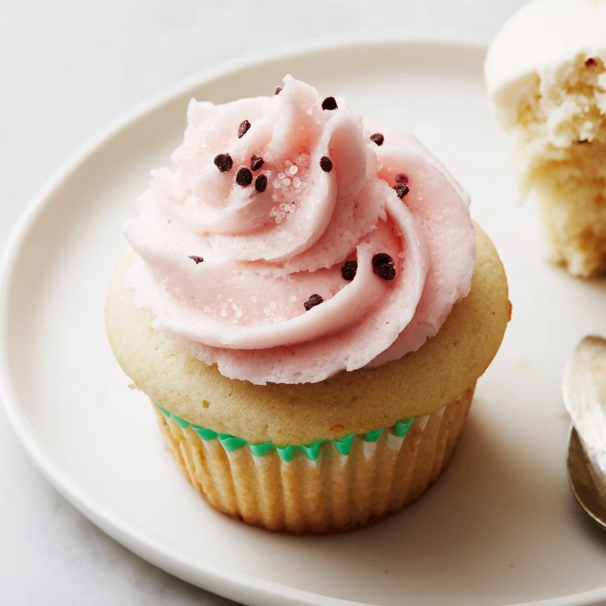 Plate of Watermelon Cupcakes topped with creamy watermelon infused frosting, rind accents