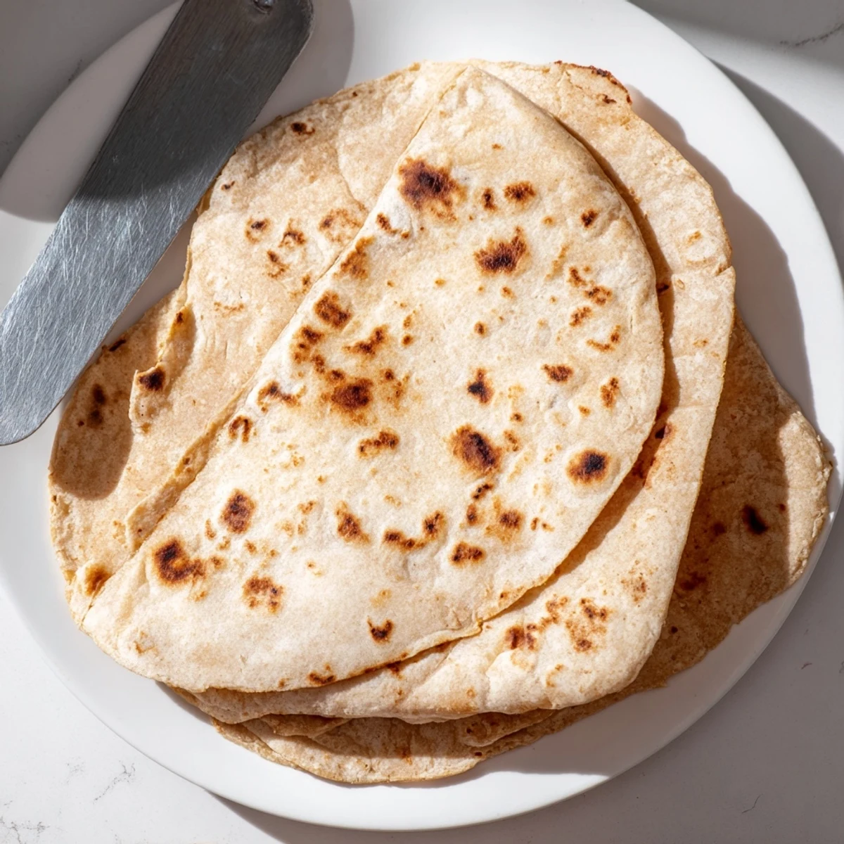 Soft pliable sweet potato cassava tortillas folded around fresh taco fillings on a white plate